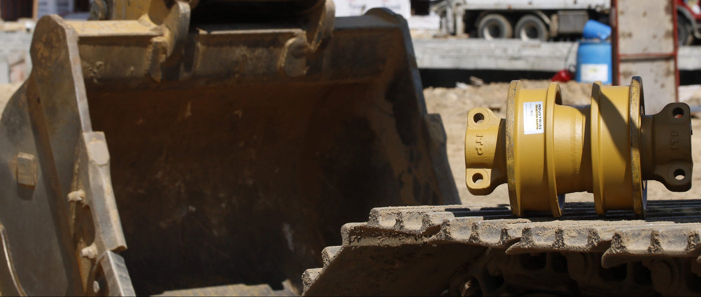 ITP-branded bottom roller resting on excavator track at an active residential construction jobsite